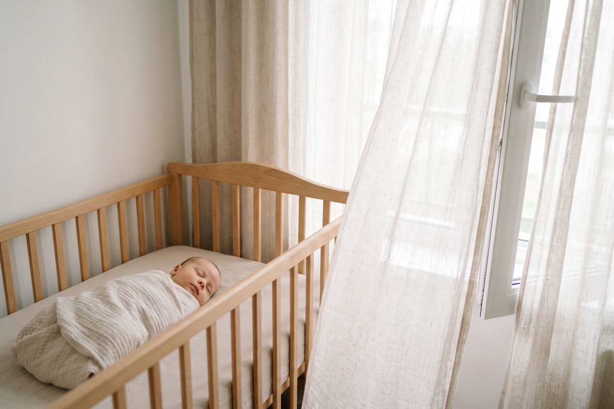 Bébé endormi dans un berceau avec un tour de lit en gaze de coton légère